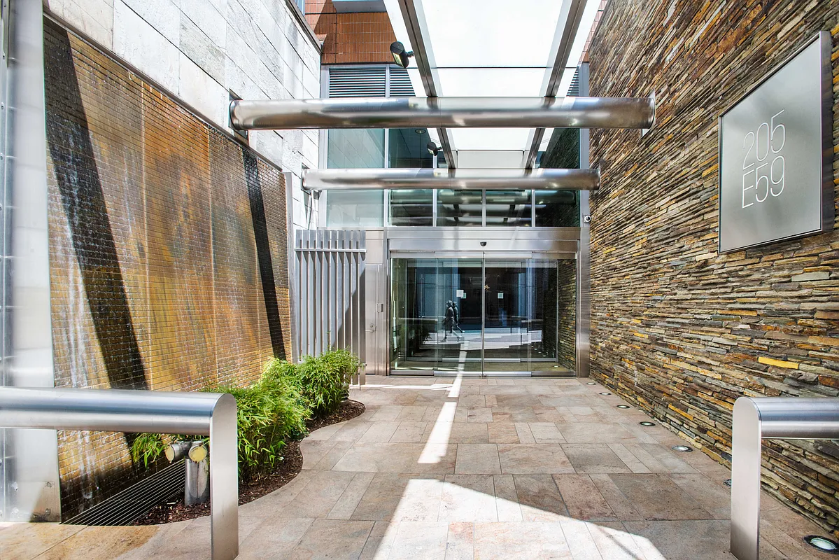 205 East 59th Street, Unit 14B Manhattan, NY 10022 - Photo 15 of 19 a front view of a building with glass door and glass door