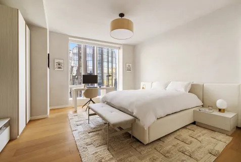 a bedroom with a bed and a large window
