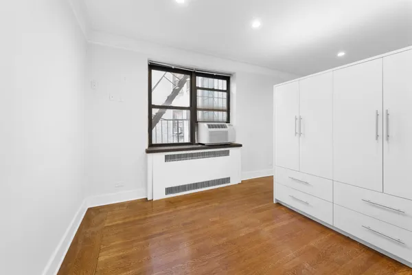 a view of empty room with cabinet and air conditioner