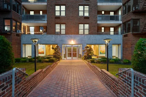 a view of a brick building next to a yard
