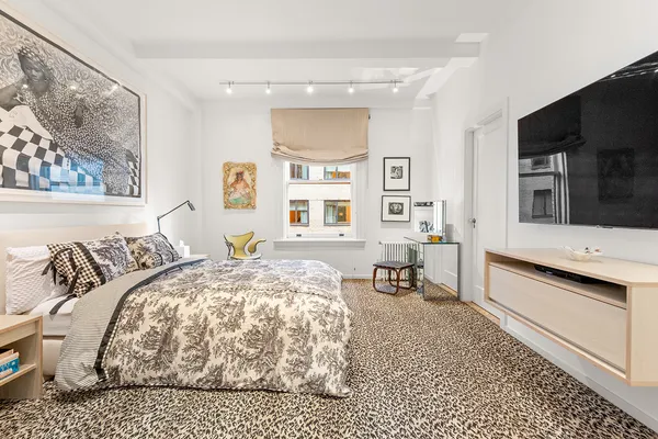 a bedroom with a bed and a flat screen tv