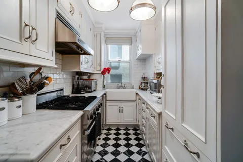 a kitchen with a sink a stove and cabinets