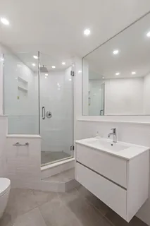 a bathroom with a sink a toilet and shower