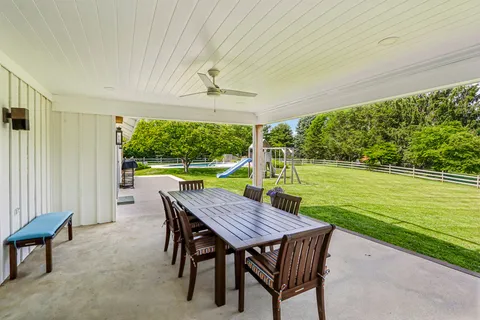a view of a patio with a table chairs and a backyard