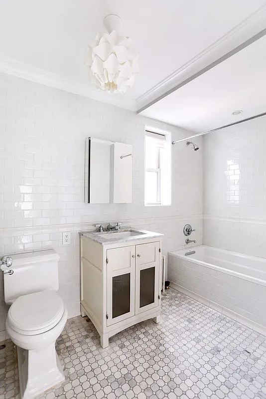 167 East 82nd Street, Unit 9B Manhattan, NY 10028 - Photo 11 of 15 a bathroom with a bathtub sink mirror and toilet