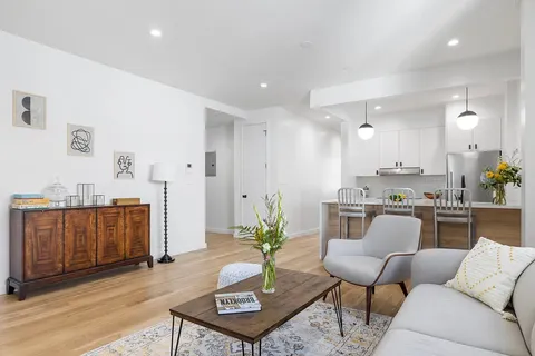 a living room with kitchen island furniture and a kitchen view