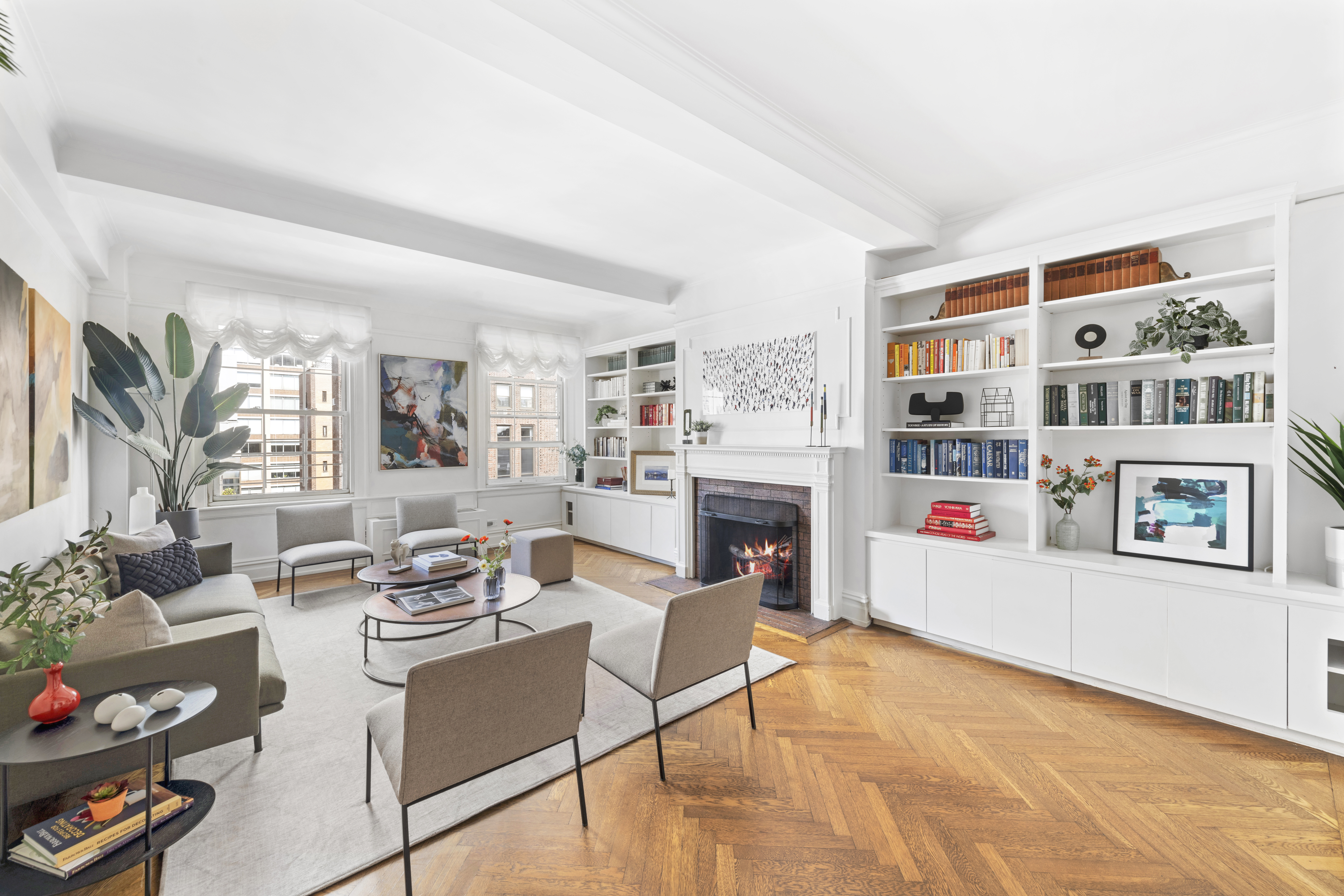 410 East 57th Street, Unit 15BE Manhattan, NY 10022 - Photo 2 of 18 a living room with furniture a fireplace and a book shelf