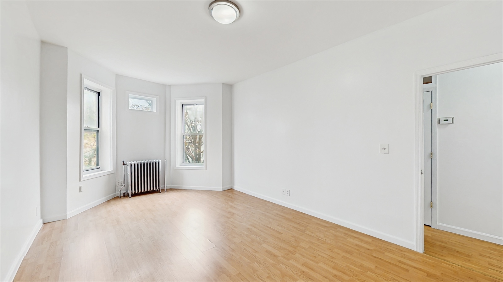 454 77th Street, Unit 3 Brooklyn, NY 11209 - Photo 7 of 25 a view of an empty room with wooden floor and a window