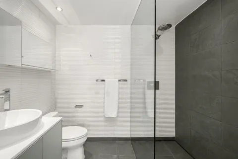 a bathroom with a granite countertop shower a toilet and a sink