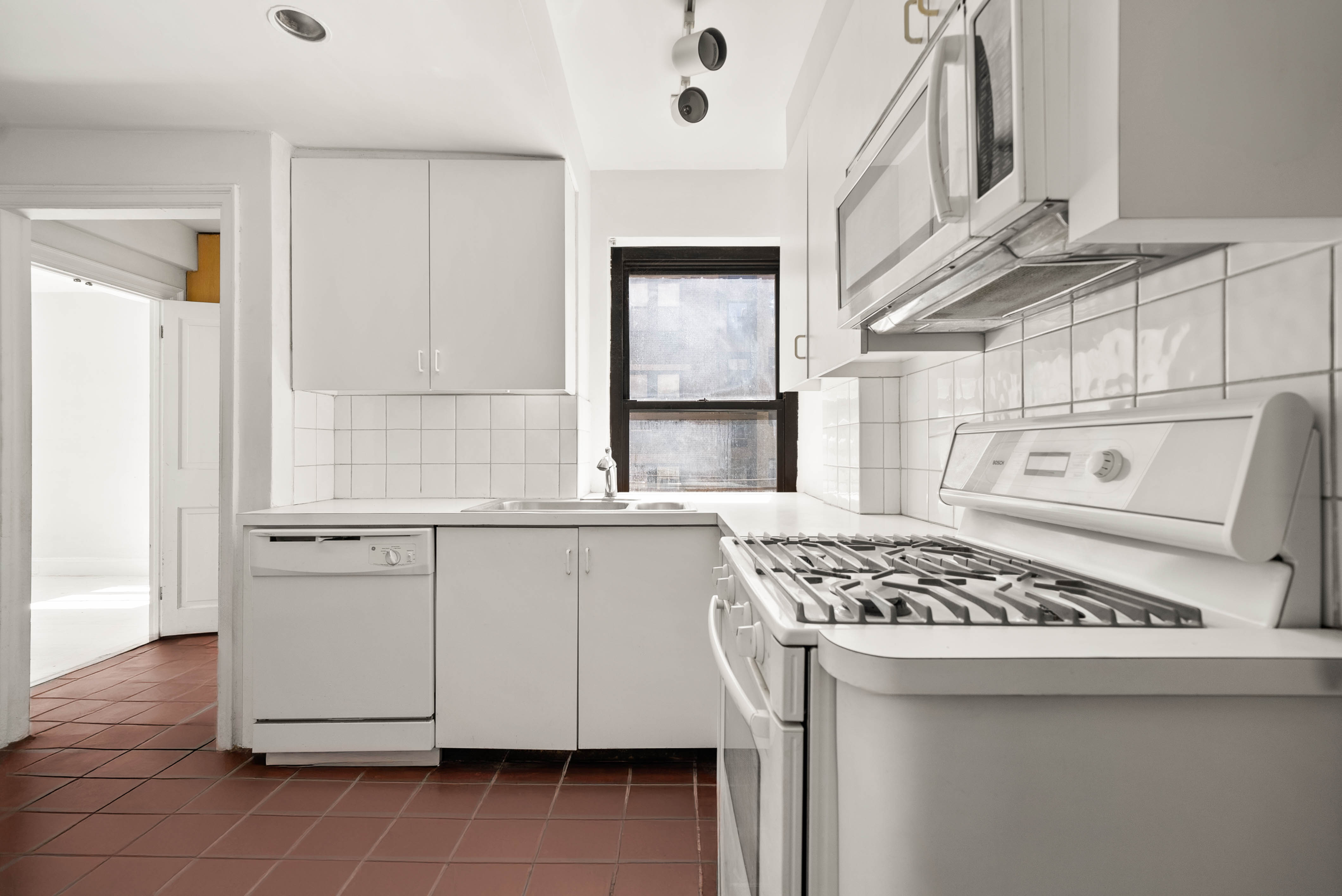 12 East 88th Street, Unit PH11/12B Manhattan, NY 10128 - Photo 14 of 22 a kitchen with a stove a sink and a refrigerator