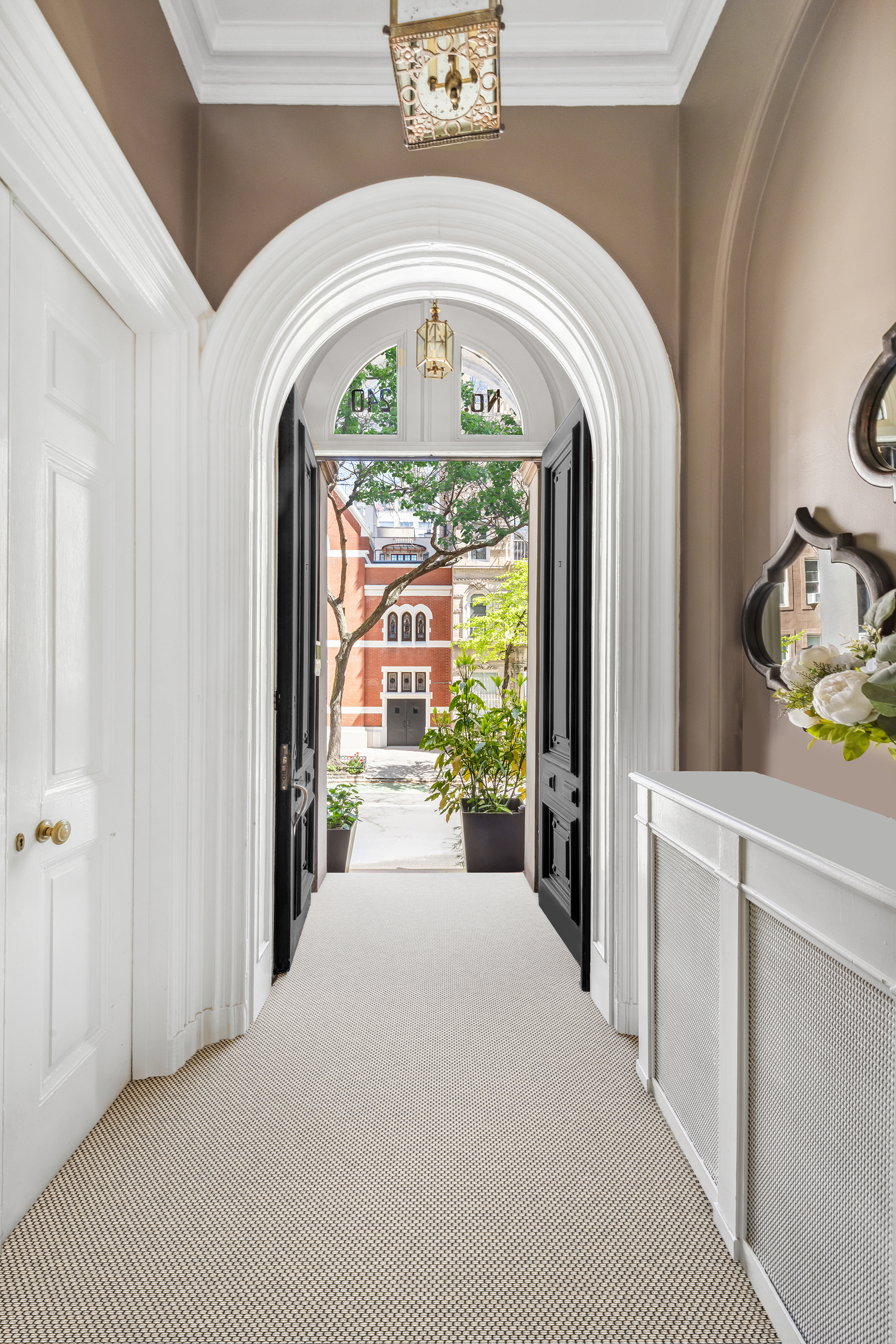 240 East 62nd Street Manhattan, NY 10065 - Photo 2 of 12 a view of a hallway with entryway windows and a chandelier