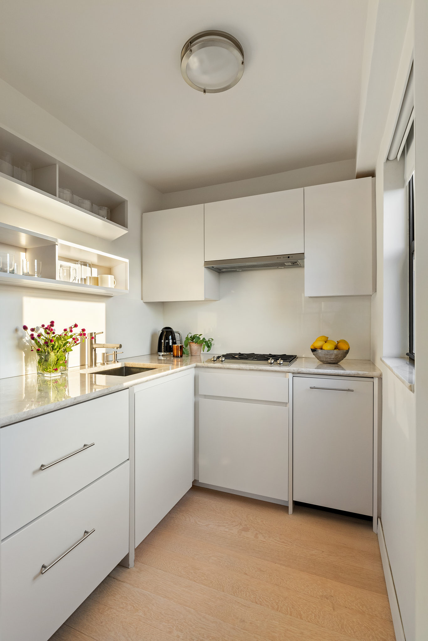 31 Jane Street, Unit 16A Manhattan, NY 10014 - Photo 5 of 17 a kitchen with white cabinets and window