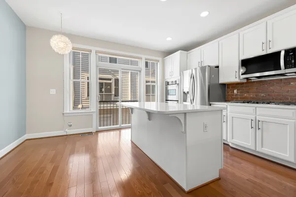 a kitchen with stainless steel appliances kitchen island granite countertop a stove a sink and a refrigerator