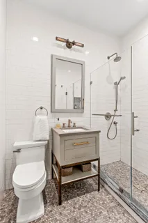 a bathroom with a toilet sink vanity and mirror