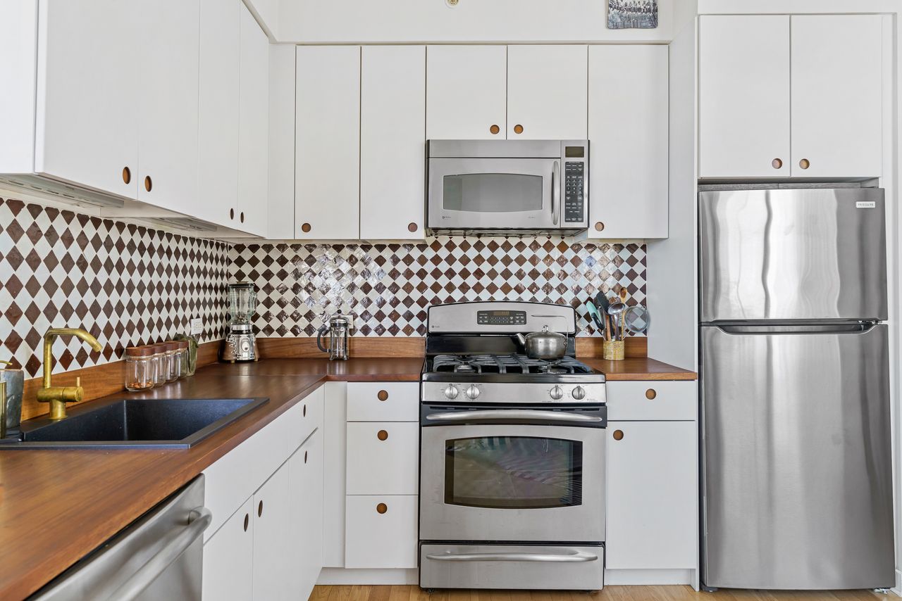 230 Ashland Place, Unit 26A Brooklyn, NY 11217 - Photo 4 of 12 a kitchen with granite countertop a sink stove and refrigerator