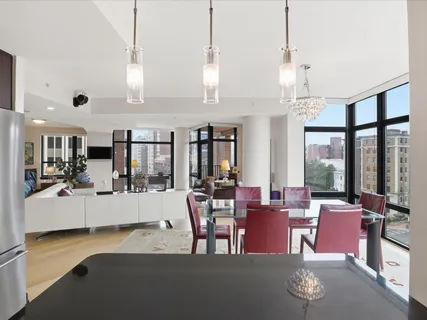 a view of a dining room and livingroom with furniture wooden floor a chandelier