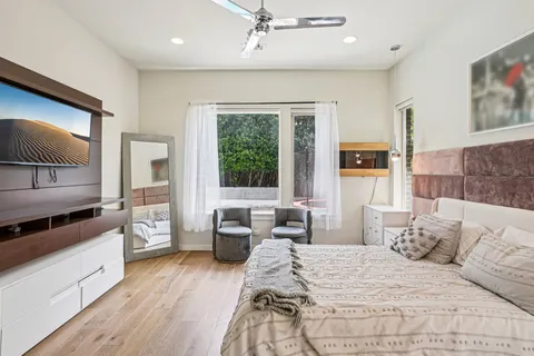 a bedroom with a large bed and a flat screen tv