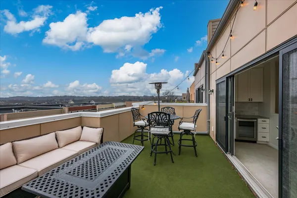 a view of a balcony with dining table and chairs
