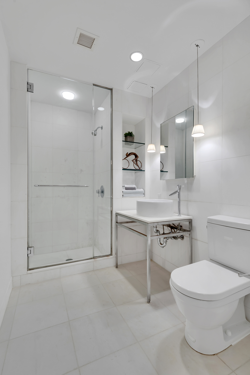 15 Broad Street, Unit 1230 Manhattan, NY 10005 - Photo 7 of 23 a bathroom with a toilet a sink and a shower