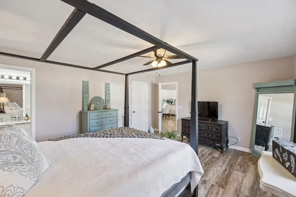 a bedroom with a bed a flat screen tv and dresser