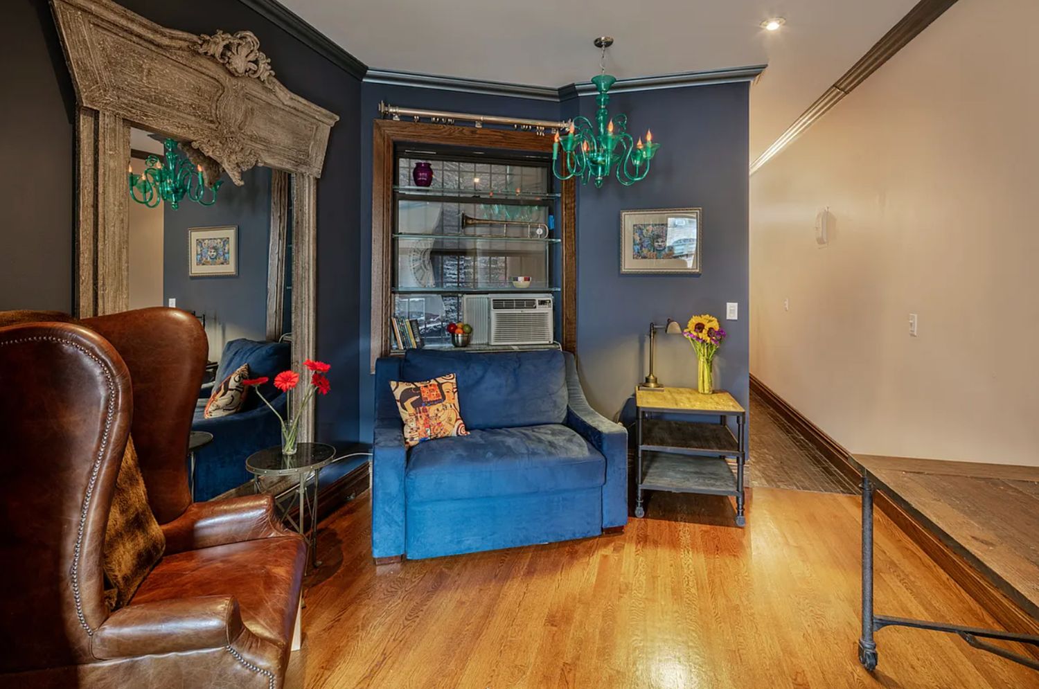 442 Amsterdam Avenue, Unit 3B Manhattan, NY 10024 - Photo 2 of 7 a living room with furniture and a chandelier