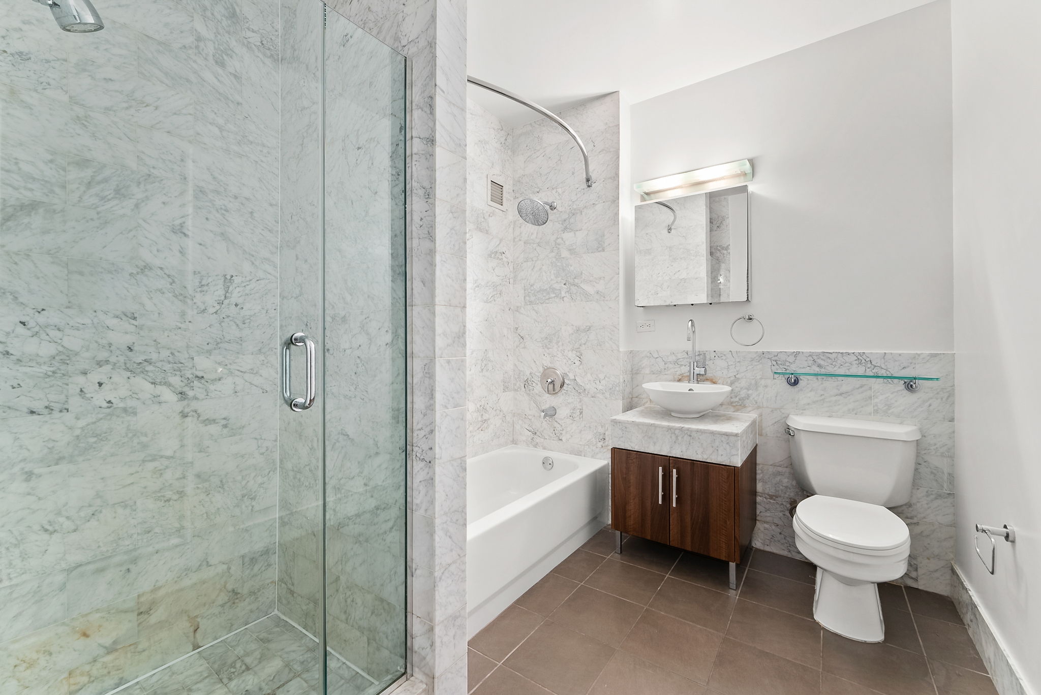 1 Wall Street Court, Unit 1405 Manhattan, NY 10005 - Photo 11 of 19 a bathroom with a toilet a sink and bathtub