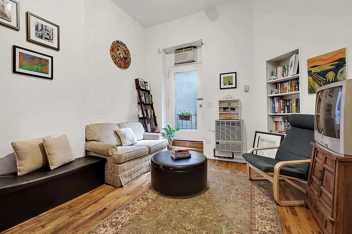 949 Columbus Avenue, Unit 1 Manhattan, NY 10025 - Photo 1 of 6 a living room with furniture and a book shelf