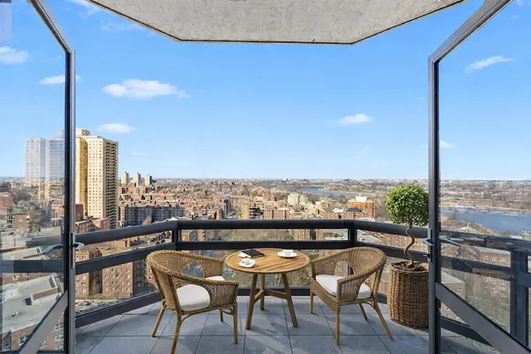 a view of a balcony with a table chairs and wooden floor