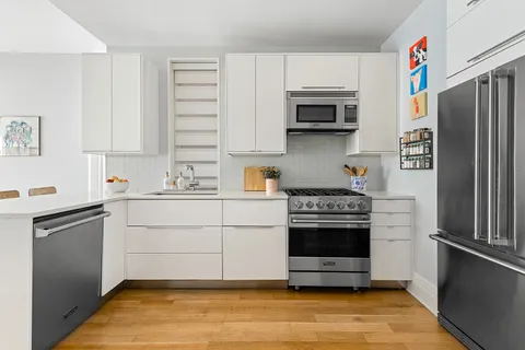 a kitchen with stainless steel appliances a stove a microwave and a refrigerator