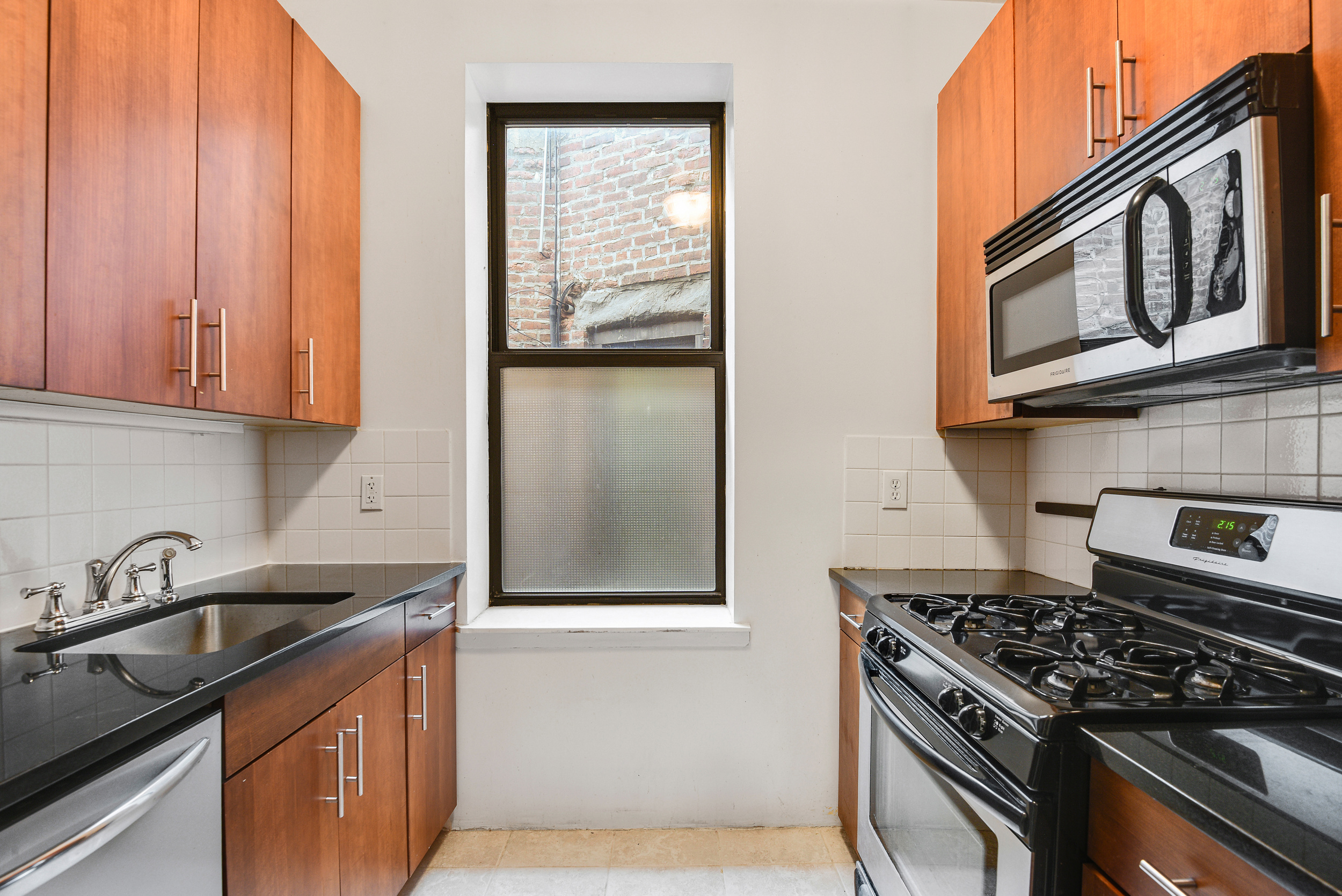 120 2nd Avenue, Unit 5A Manhattan, NY 10003 - Photo 8 of 10 a kitchen with granite countertop a stove sink and cabinets