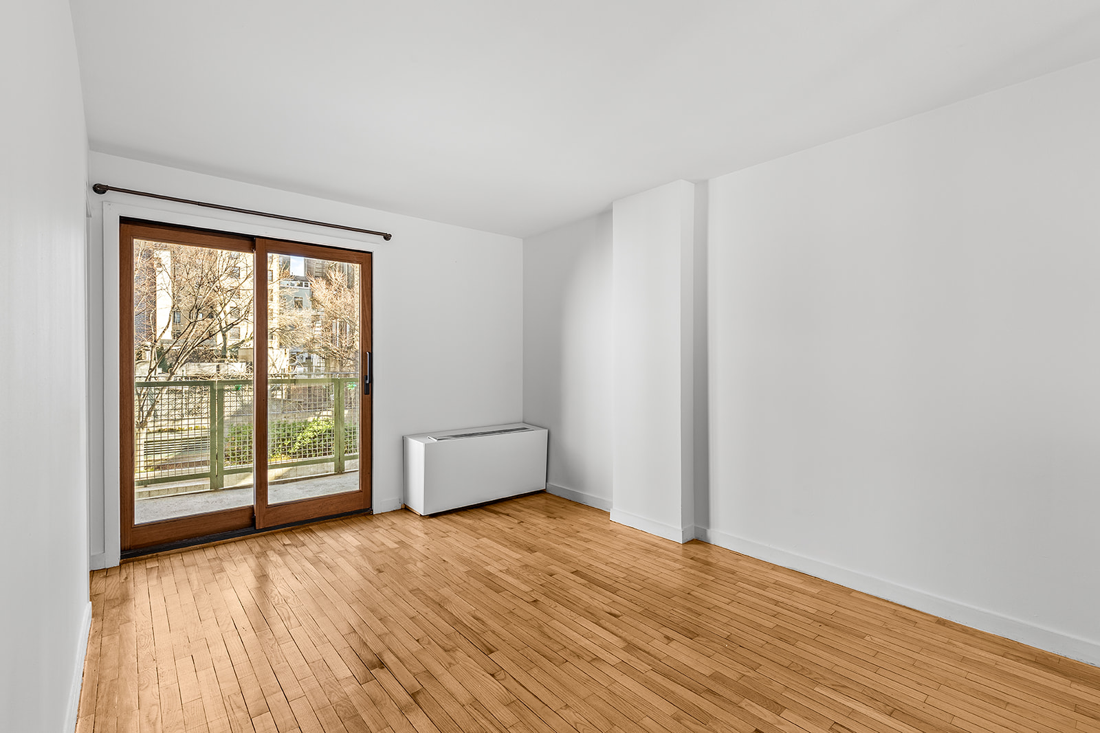 126 Waverly Place, Unit 2F Manhattan, NY 10011 - Photo 8 of 11 an empty room with wooden floor and windows
