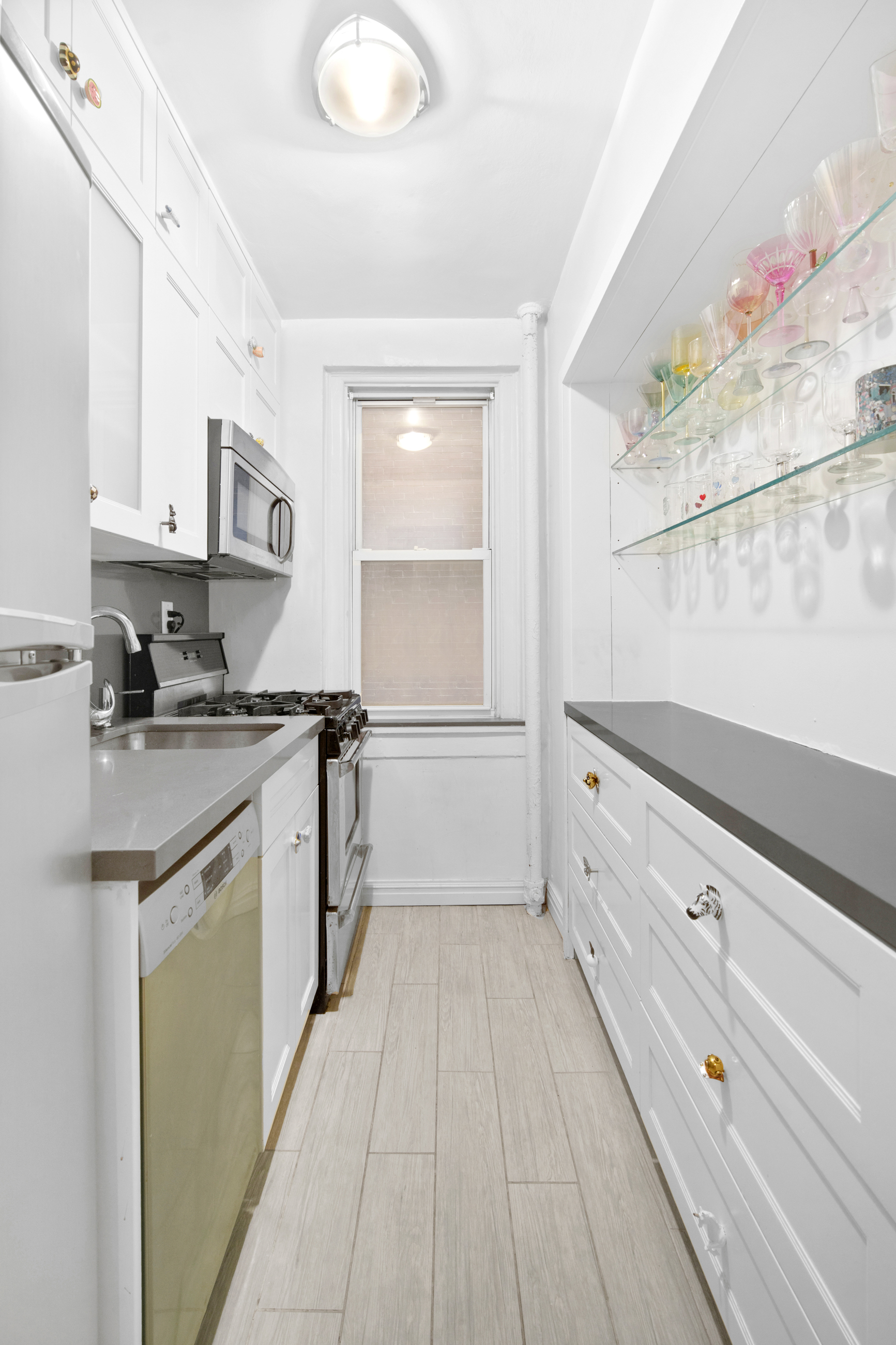 110 East 87th Street, Unit 3F Manhattan, NY 10128 - Photo 2 of 8 a kitchen with granite countertop white cabinets and white appliances