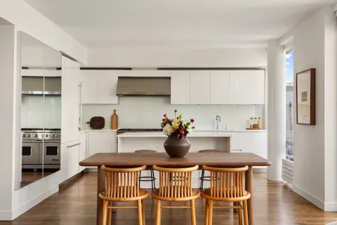 a kitchen with a table chairs a sink and dishwasher