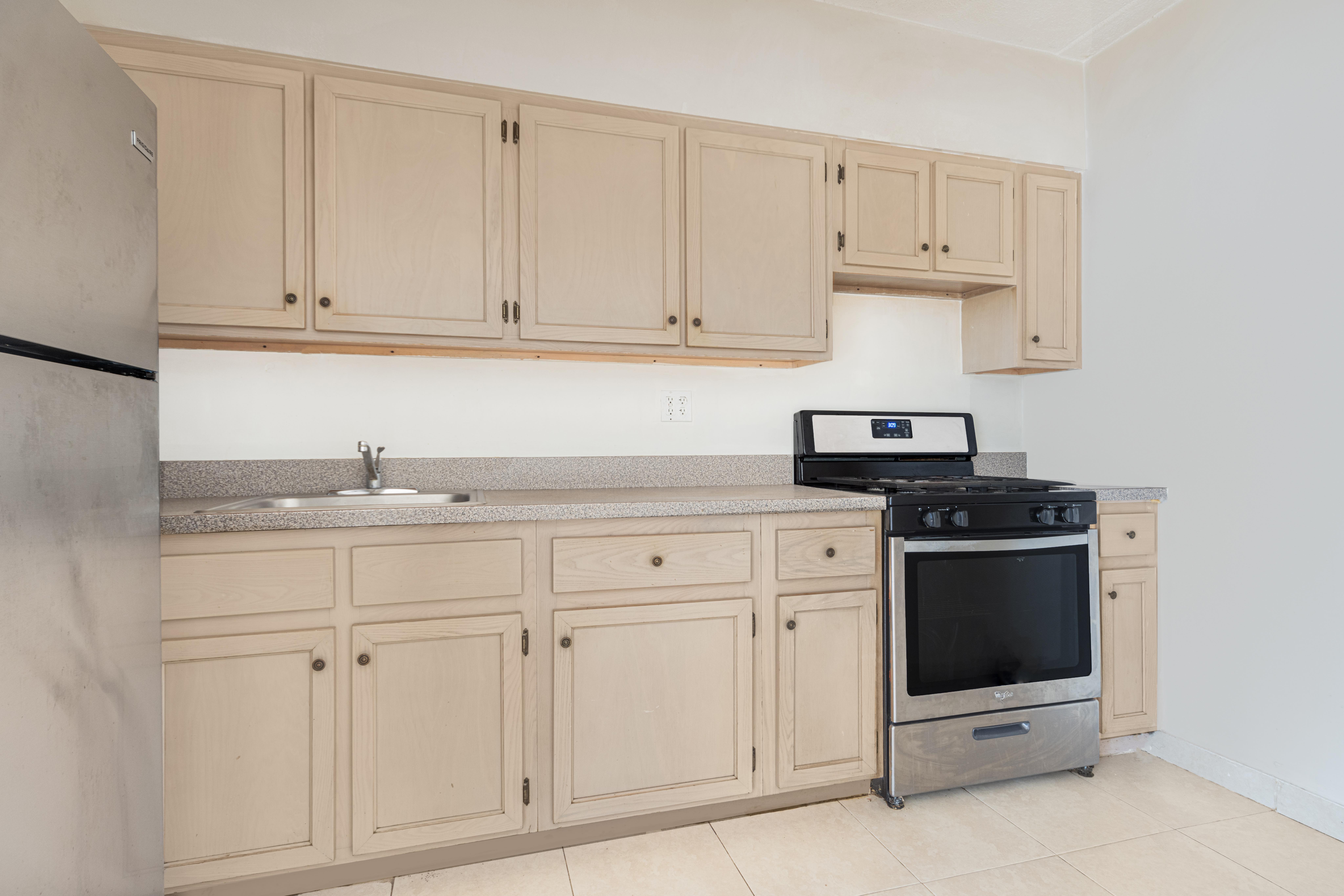 125 West 117th Street Manhattan, NY 10026 - Photo 18 of 23 a kitchen with white cabinets and sink