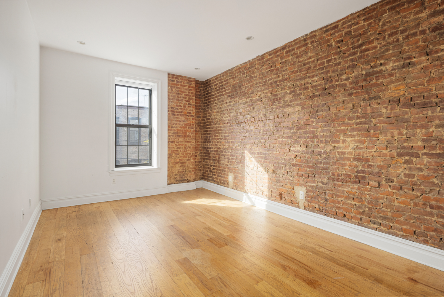 912 Eastern Parkway, Unit 1 Brooklyn, NY 11213 - Photo 5 of 11 a view of an empty room with a window and wooden floor