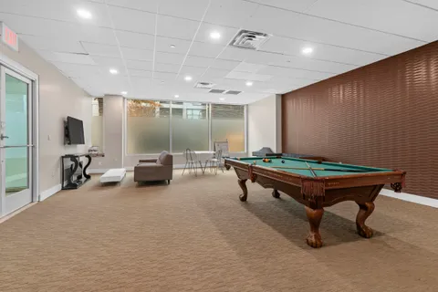 a room with furniture pool table and a flat screen tv