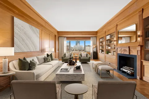 a living room with furniture fireplace and a large window