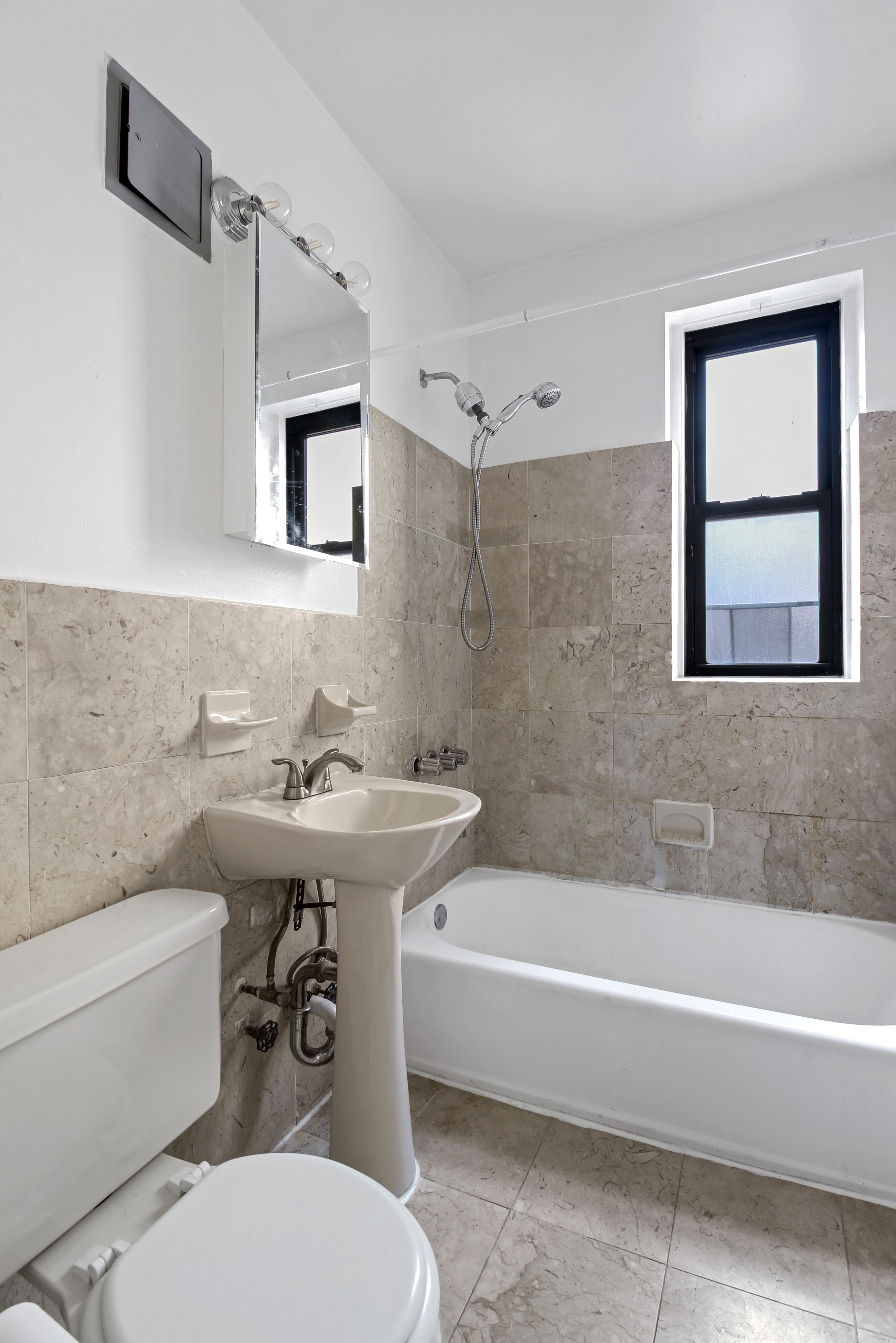 315 East 56th Street, Unit 6C Manhattan, NY 10022 - Photo 5 of 5 a bathroom with a sink mirror bathtub and toilet