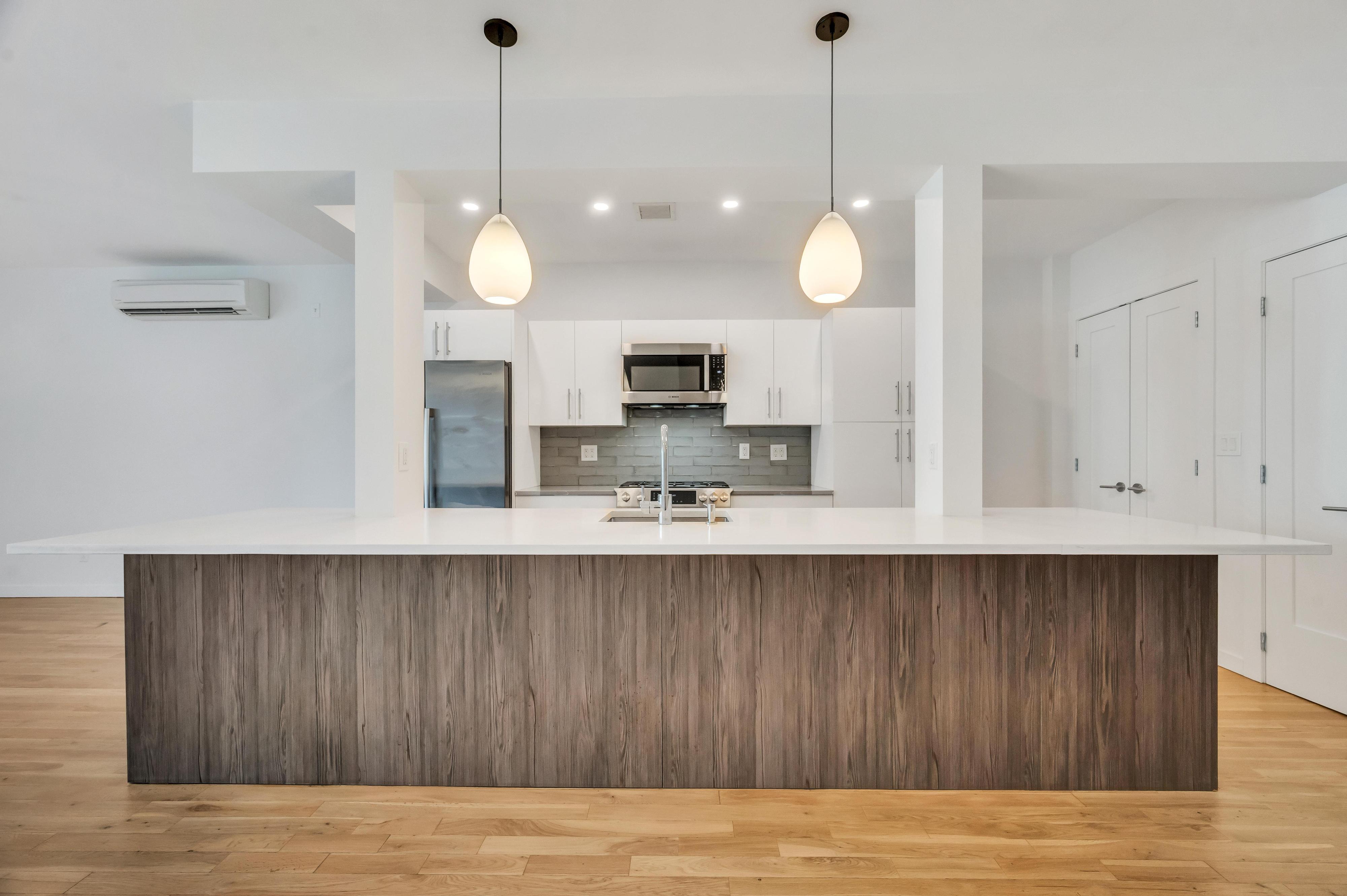 717 Manhattan Avenue, Unit 3A Brooklyn, NY 11222 - Photo 4 of 18 a view of a kitchen with wooden floor and a sink