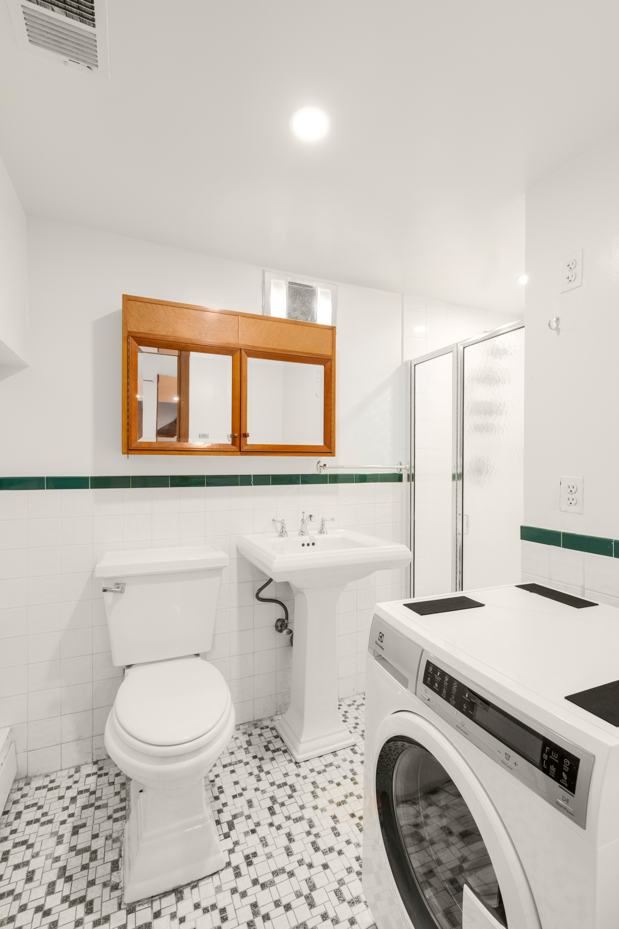 252 West 102nd Street, Unit 1 Manhattan, NY 10025 - Photo 8 of 11 a bathroom with a sink a toilet and a mirror