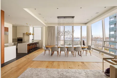 a living room with furniture large windows dining table and a large window