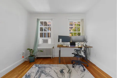 a bed sitting in a bedroom next to a window