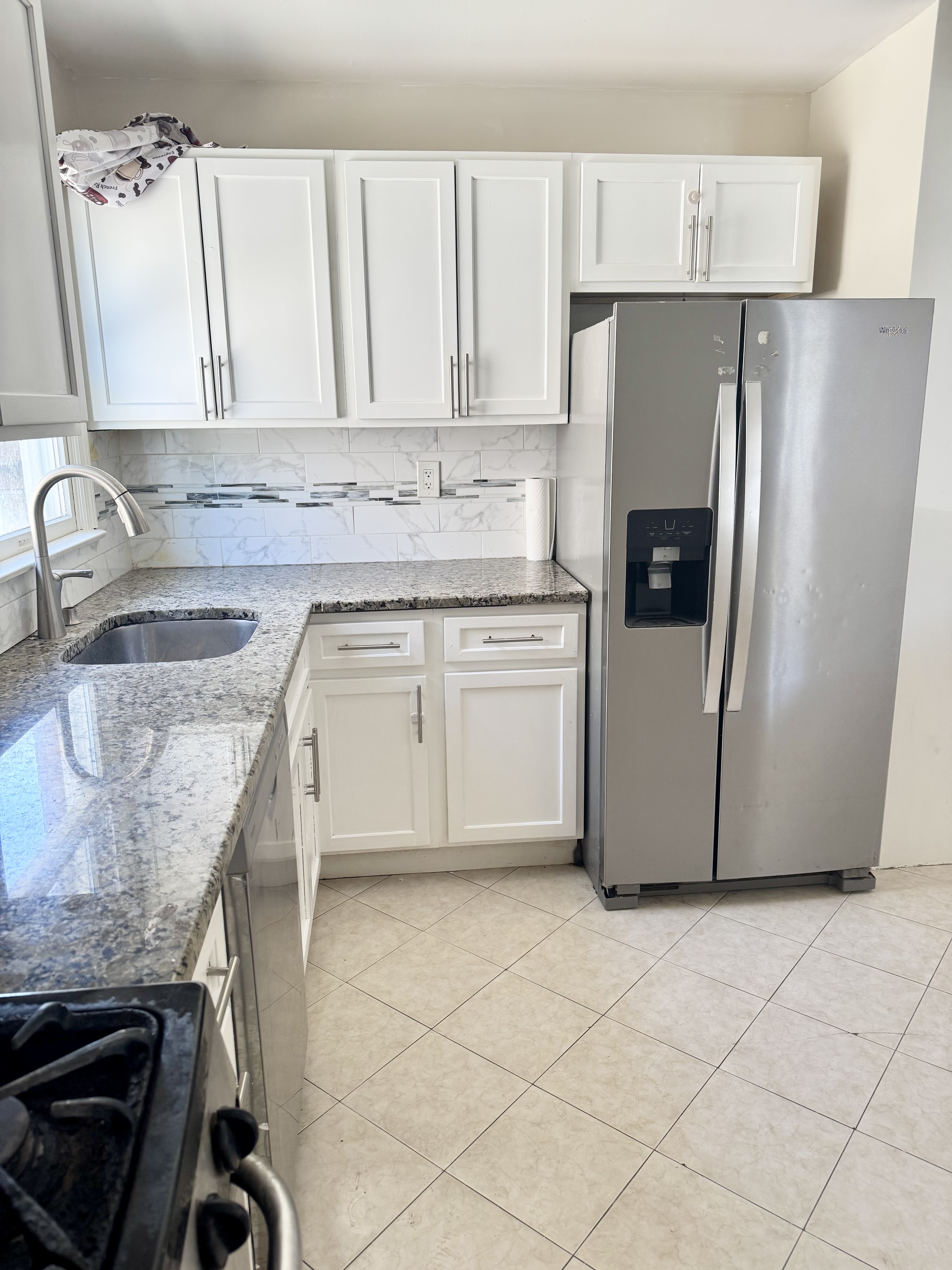 a kitchen with granite countertop a sink stove and refrigerator