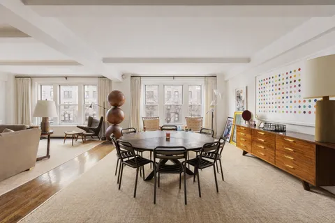 a dining room with furniture and a large window