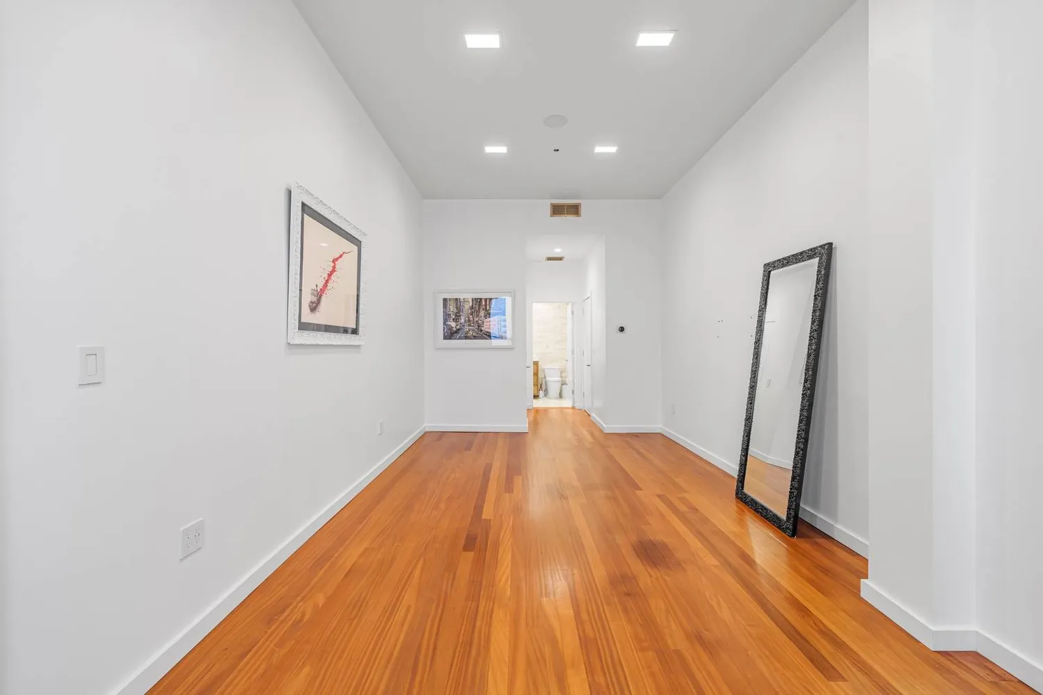 a view of empty room with wooden floor