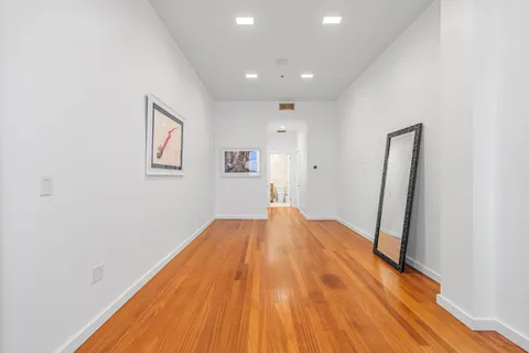 a view of empty room with wooden floor