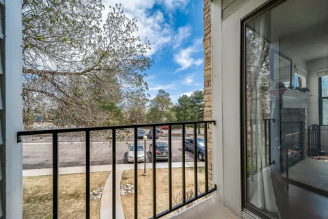 a view of a balcony with a floor to ceiling window and wooden fence