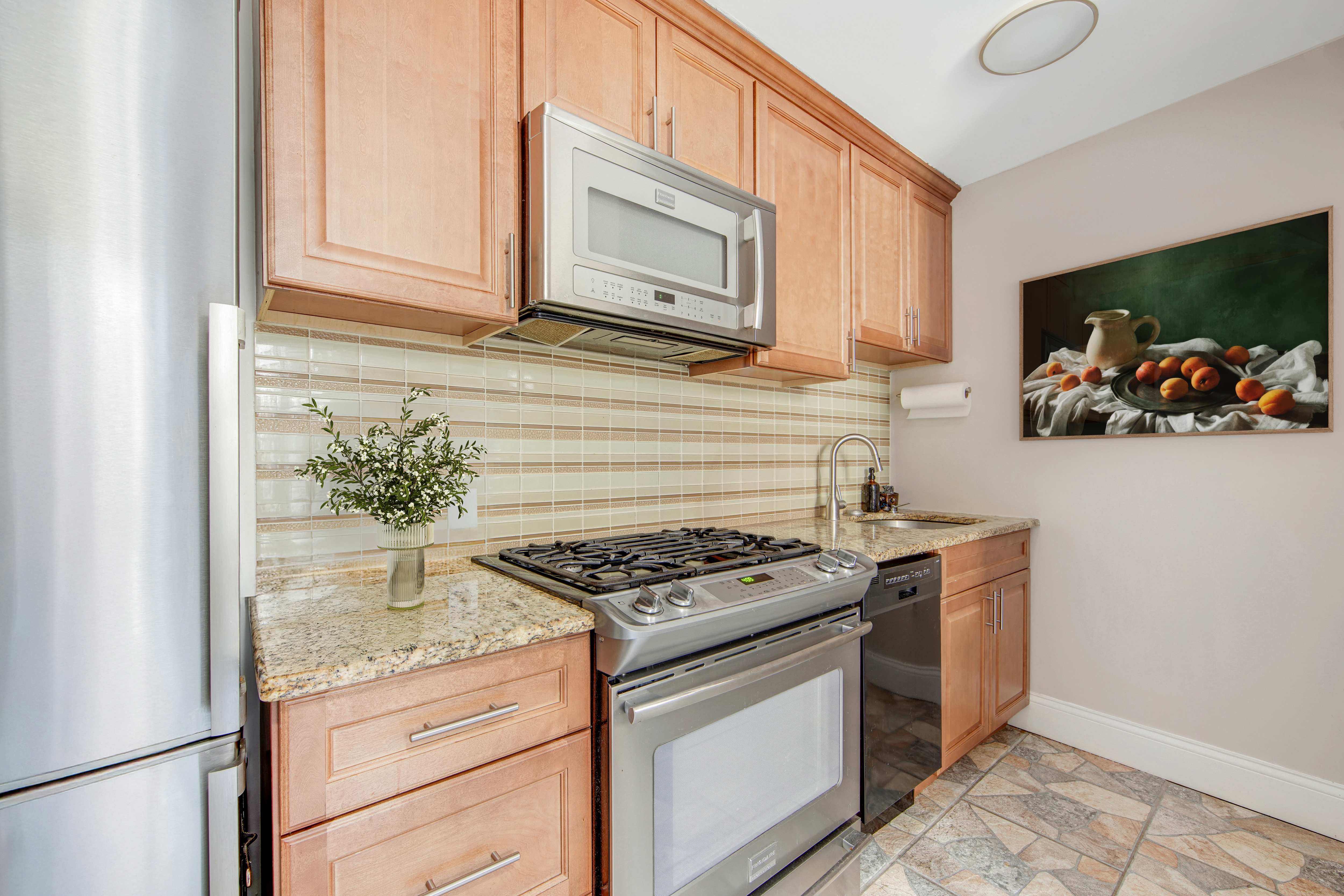 165 West 91st Street, Unit 15B Manhattan, NY 10024 - Photo 5 of 24 a kitchen with stainless steel appliances granite countertop a stove and a microwave