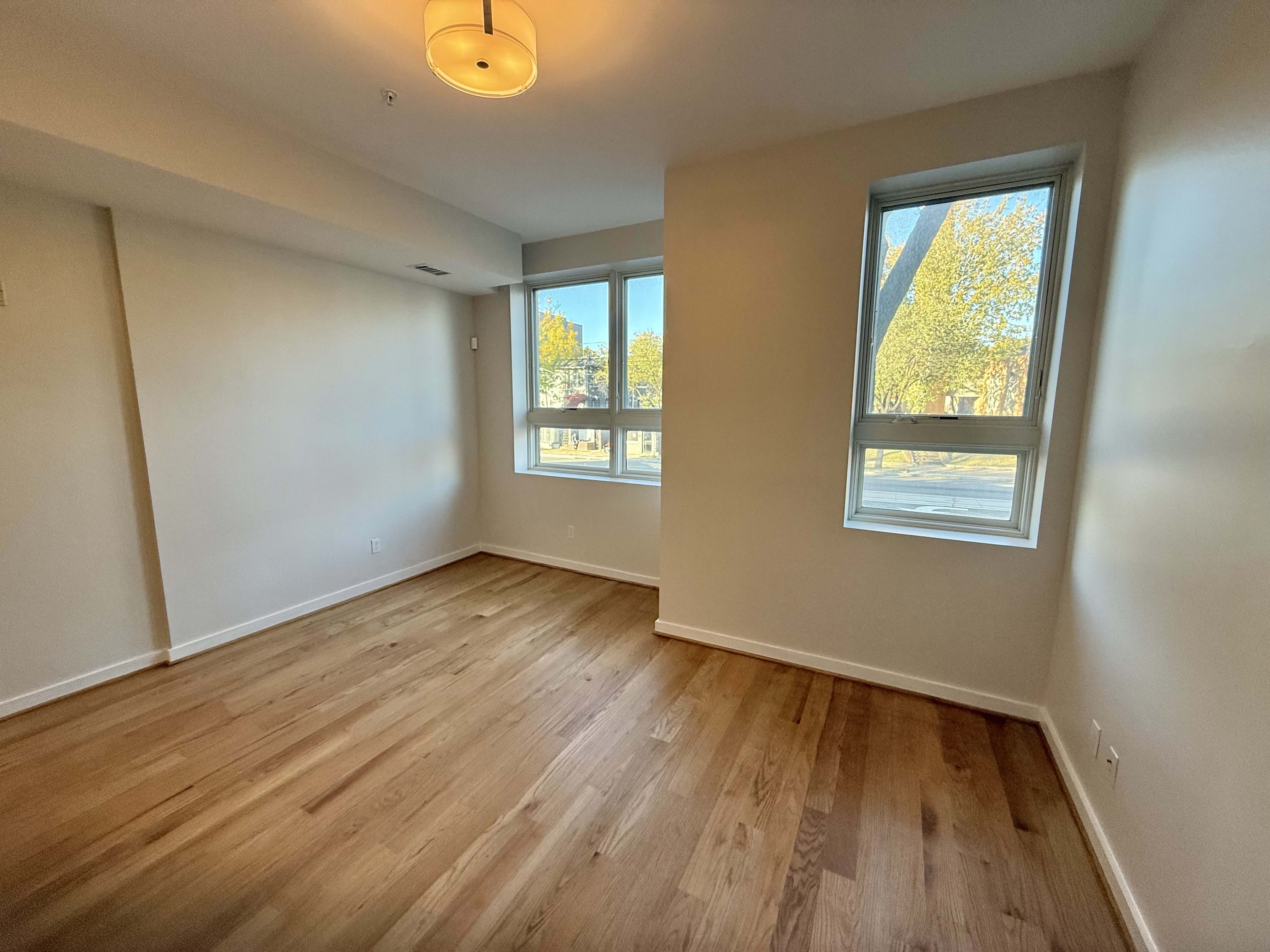 2009 Benning Road Northeast, Unit 2 Washington, DC 20002 - Photo 3 of 11 a view of an empty room with wooden floor and a window