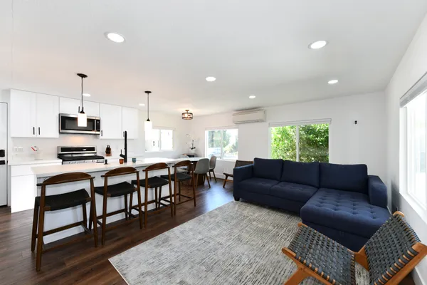 a living room kitchen with furniture and a wooden floor